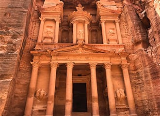 A large building with pillars and carvings on it.