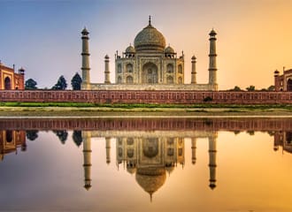 A view of the taj mahal from across the water.