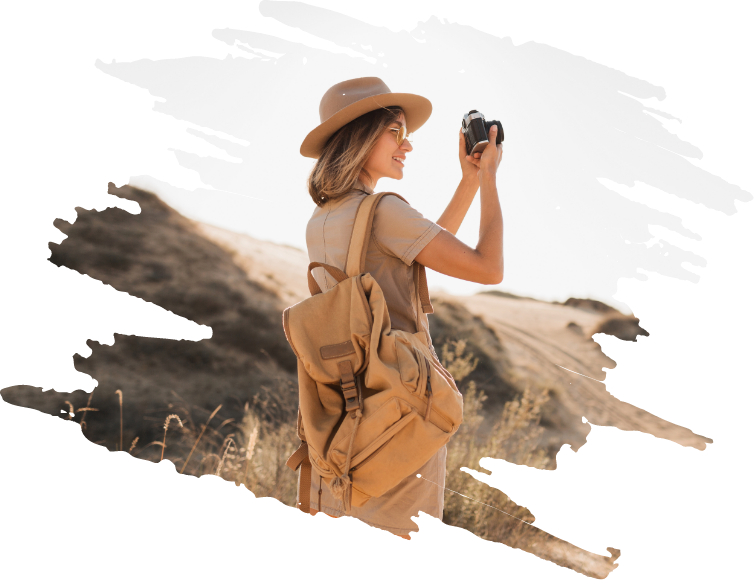 A woman in a hat and backpack taking a picture