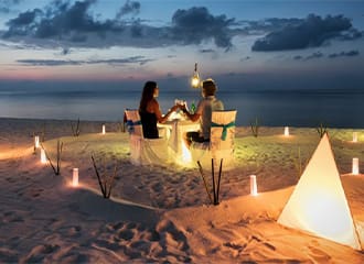 A couple is sitting at the table on the beach