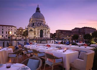 A restaurant with tables and chairs set up for dinner.