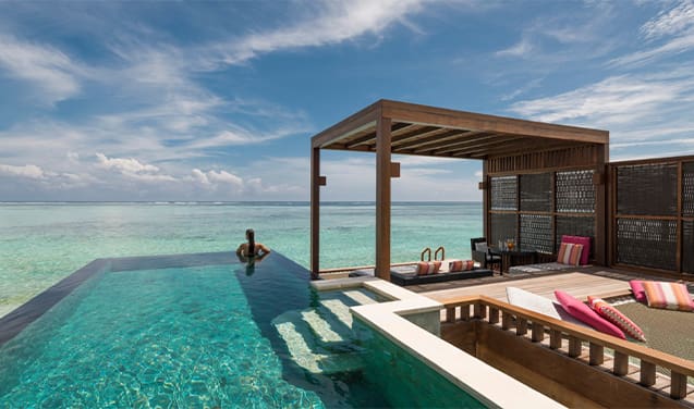 A person sitting on the edge of an ocean pool.