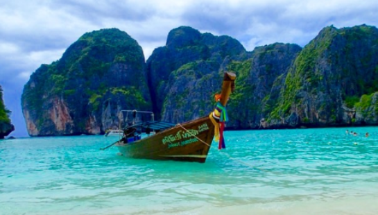 A boat floating in the water near some mountains