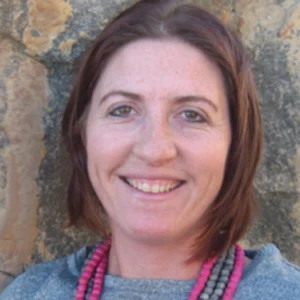 A woman with long brown hair wearing a necklace.