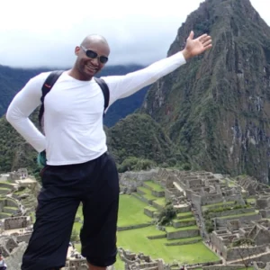 A man standing on top of a mountain with his arms outstretched.