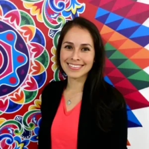 A woman standing in front of a colorful wall.