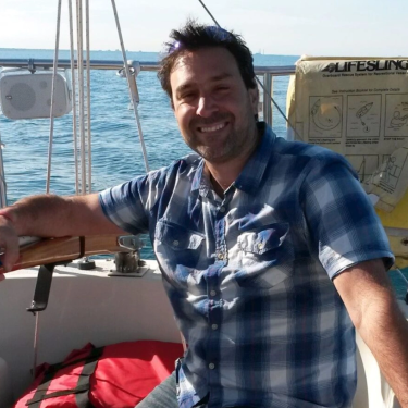 A man standing on the side of a boat.