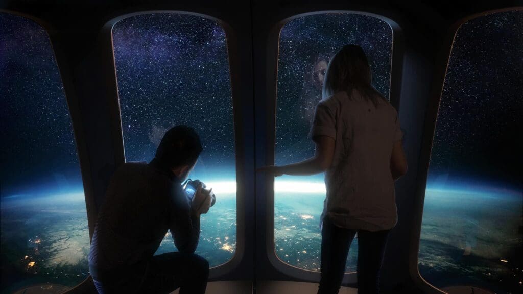 Two people looking out a window at the night sky.