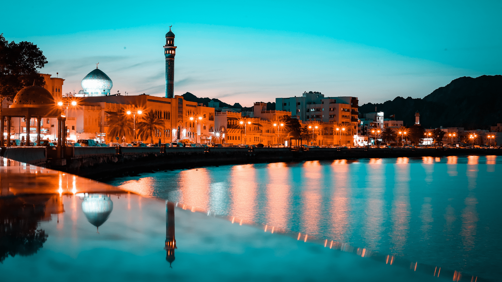 A city with lights reflecting on the water.