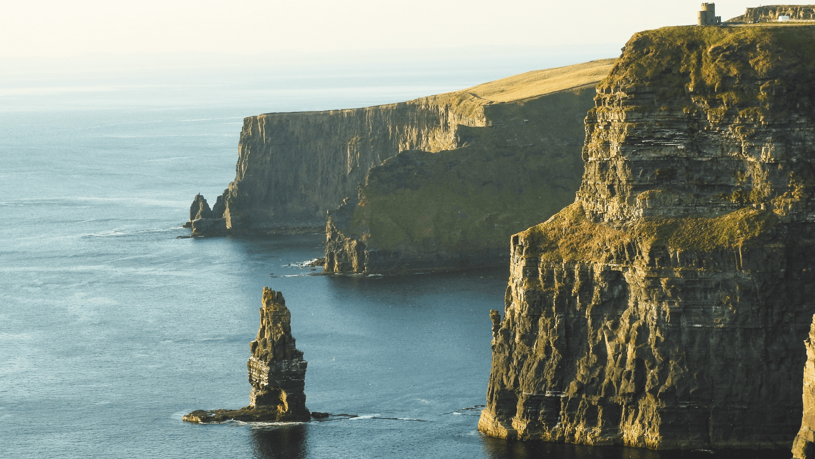 A large rock formation in the middle of the ocean.