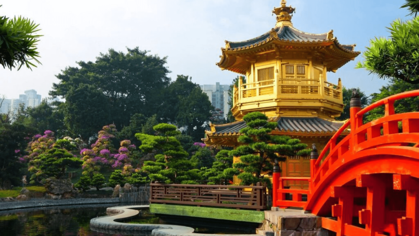 A gold pagoda with trees and bushes in the background.