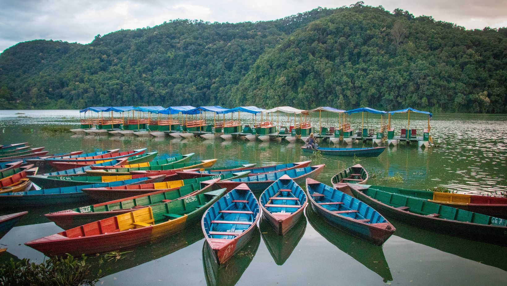 A group of boats floating on top of water.