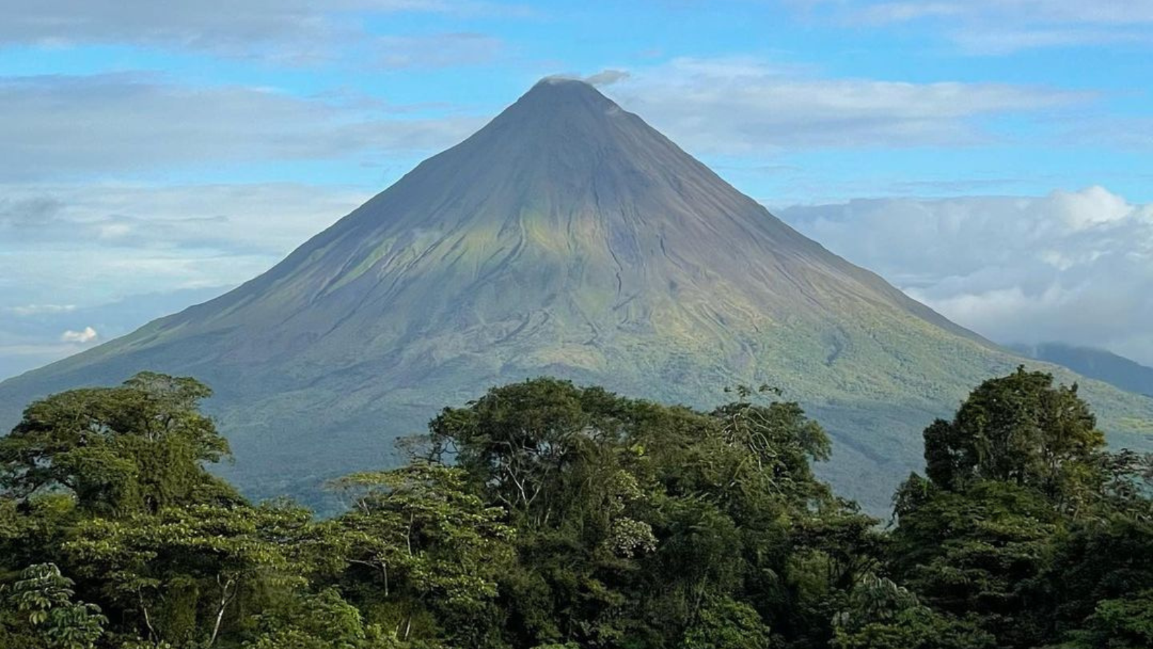 A very tall mountain with a large peak in the background.