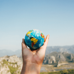 A person holding a small globe in their hand.