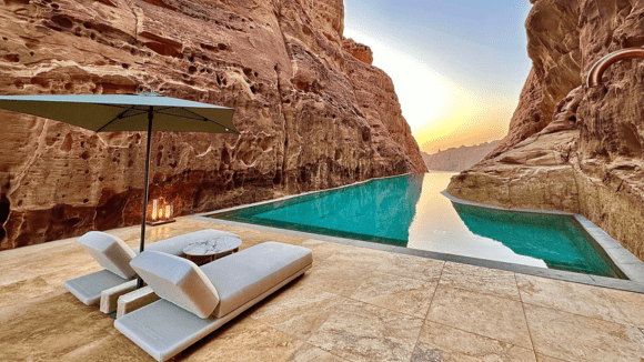 A pool with a view of the water and mountains.