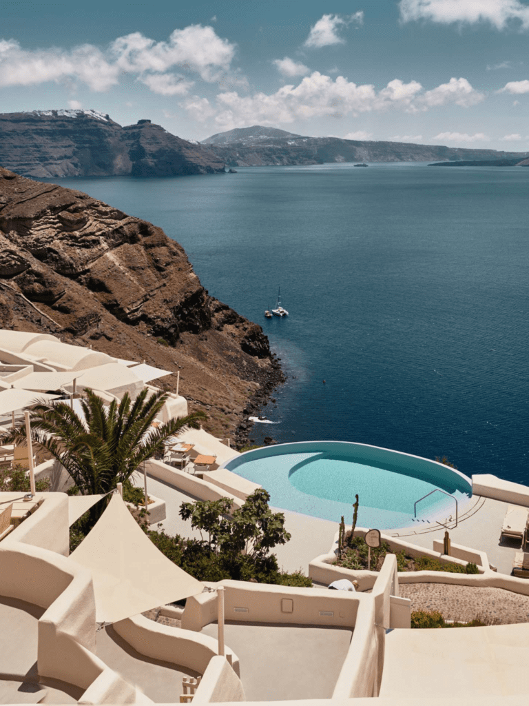 A pool on the side of a cliff overlooking water.