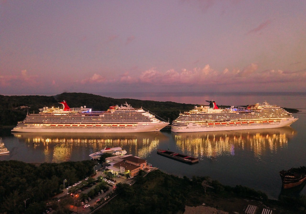 Two cruise ships are docked in a harbor.